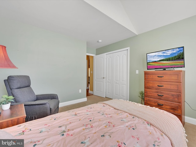 carpeted bedroom with vaulted ceiling and a closet