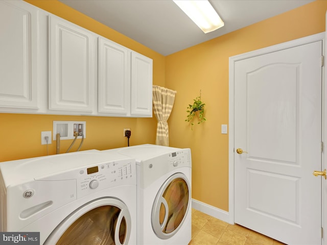 clothes washing area featuring cabinets, washer and dryer, and light tile patterned floors