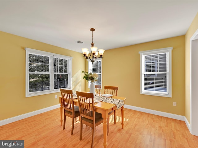 dining space featuring a notable chandelier and light hardwood / wood-style floors