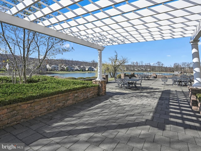 view of patio featuring a pergola and a water view