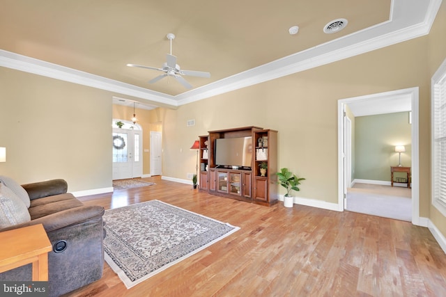 living room featuring ceiling fan, ornamental molding, and light wood-type flooring