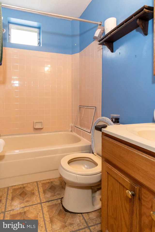 full bathroom with vanity, tiled shower / bath, tile patterned flooring, and toilet