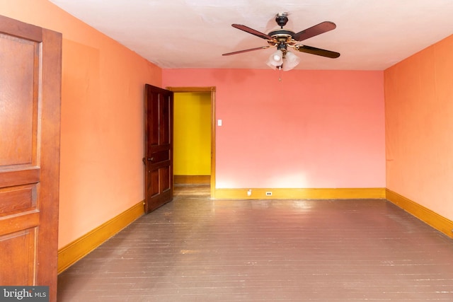 spare room with dark wood-type flooring and ceiling fan