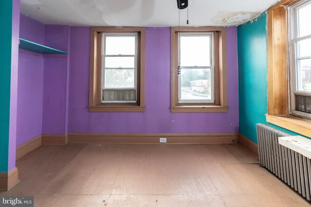 spare room featuring radiator and a wealth of natural light