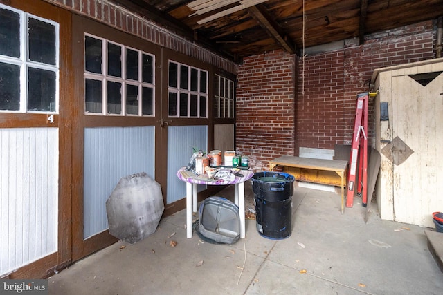 interior space featuring brick wall and concrete floors