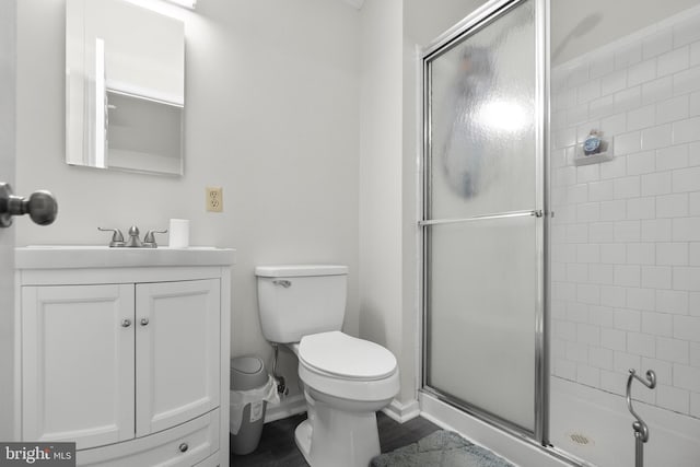 bathroom with vanity, an enclosed shower, and toilet