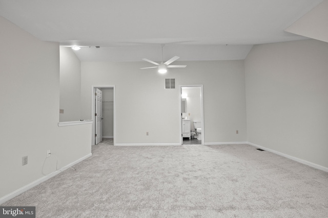 carpeted empty room featuring vaulted ceiling and ceiling fan