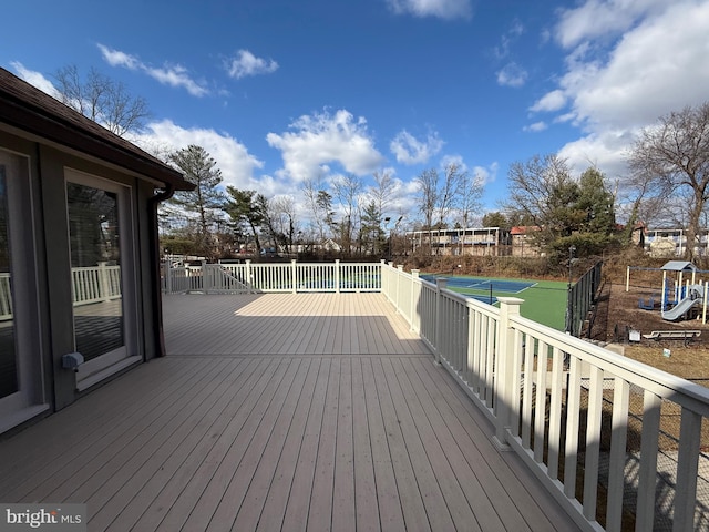 deck featuring a playground and tennis court