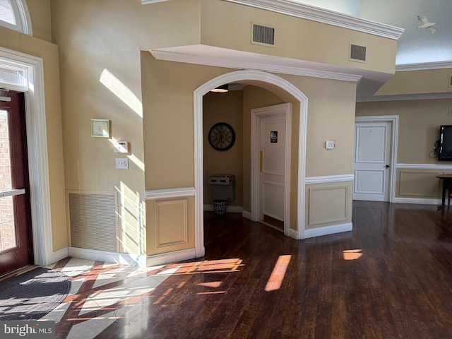 foyer featuring ornamental molding and dark hardwood / wood-style flooring