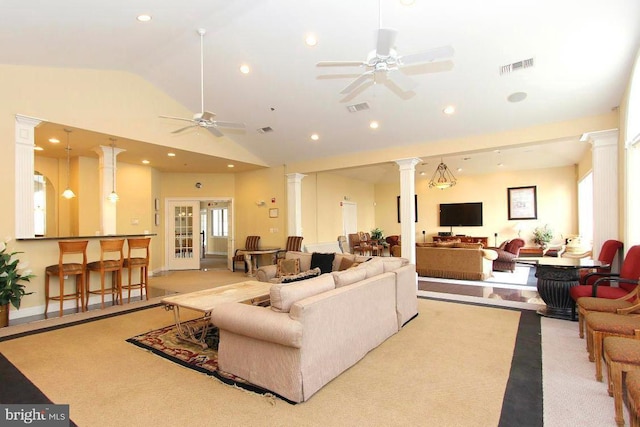 living room with lofted ceiling, plenty of natural light, decorative columns, and ceiling fan