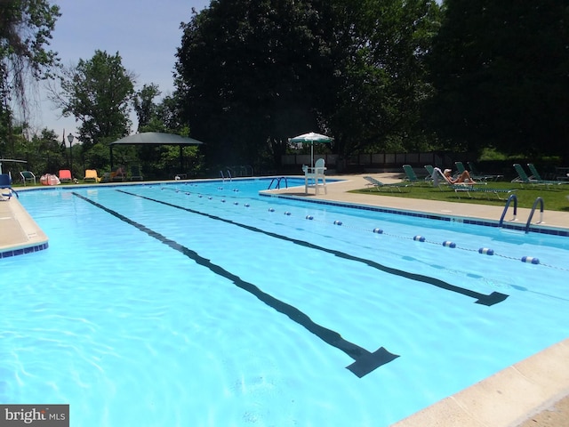 view of swimming pool with a yard