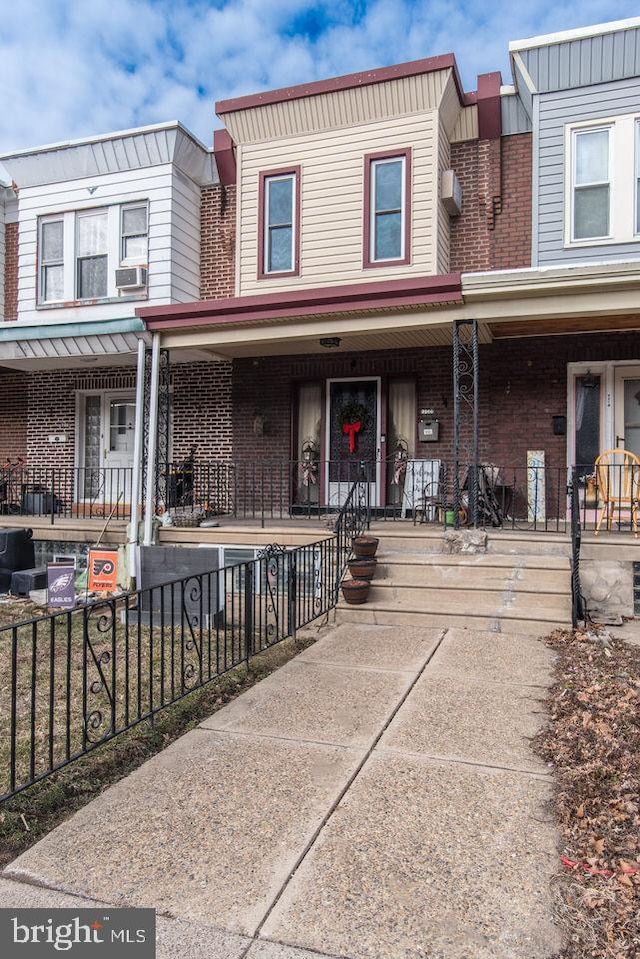 townhome / multi-family property featuring a porch and cooling unit