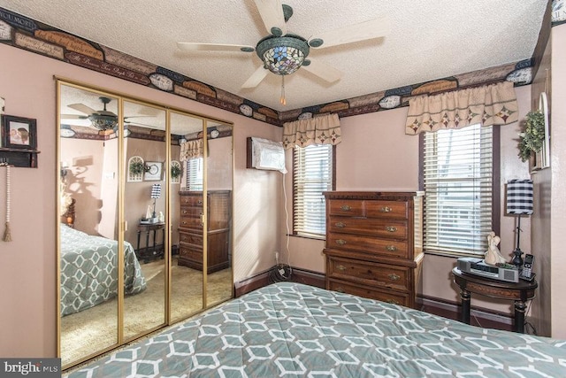 bedroom with ceiling fan, carpet flooring, a textured ceiling, and a closet