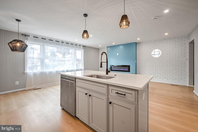 kitchen featuring a center island with sink, hanging light fixtures, dishwasher, and sink