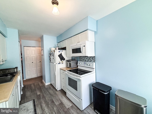 kitchen featuring sink, backsplash, dark hardwood / wood-style flooring, white cabinets, and white appliances