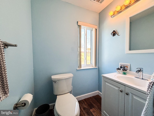 bathroom featuring vanity, wood-type flooring, and toilet