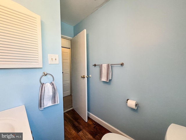 bathroom featuring wood-type flooring and toilet