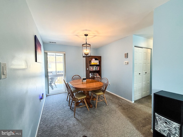 dining area with an inviting chandelier and carpet flooring