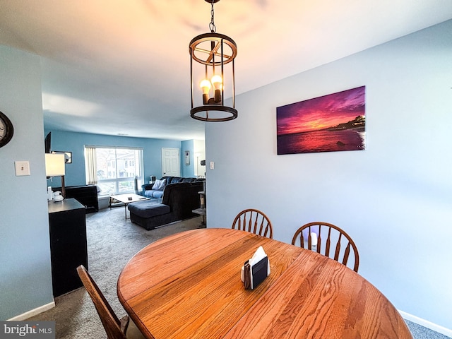 dining area with carpet floors and a chandelier