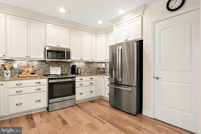 kitchen featuring white cabinetry, stainless steel appliances, light hardwood / wood-style floors, and light stone counters