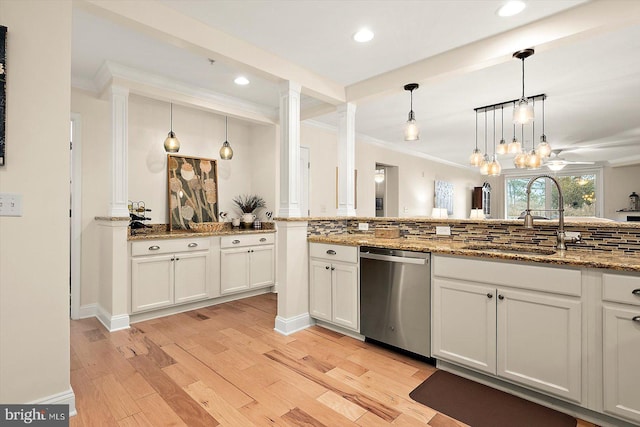 kitchen with sink, dishwasher, white cabinetry, hanging light fixtures, and stone countertops