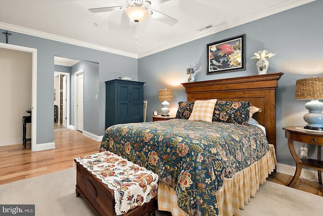 bedroom featuring ceiling fan, ornamental molding, and light hardwood / wood-style floors