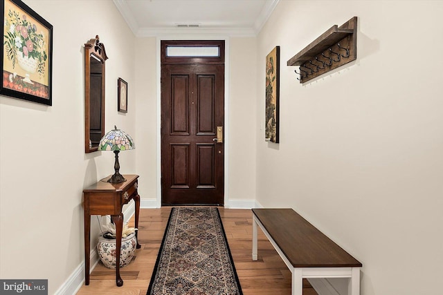 doorway to outside featuring crown molding and light wood-type flooring