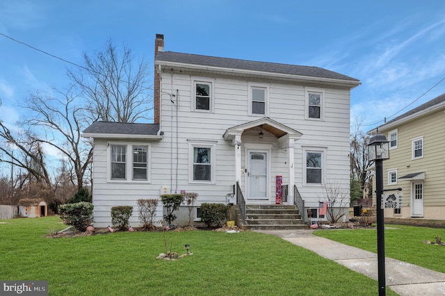 colonial inspired home featuring a front lawn