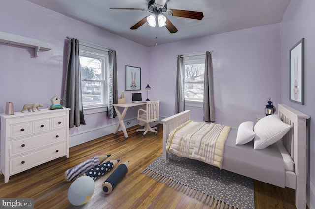 bedroom with ceiling fan, dark hardwood / wood-style flooring, and multiple windows