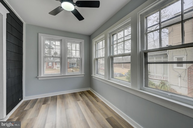 unfurnished sunroom with ceiling fan and a healthy amount of sunlight