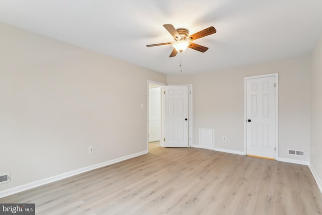 unfurnished room with light wood-style flooring, visible vents, baseboards, and a ceiling fan