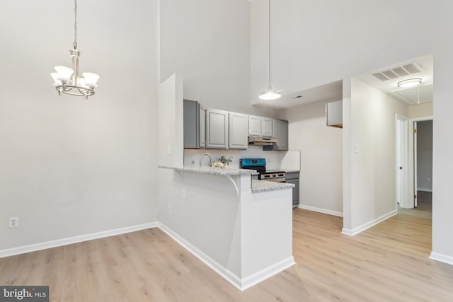 kitchen with visible vents, light wood-style floors, stainless steel electric range oven, gray cabinetry, and under cabinet range hood