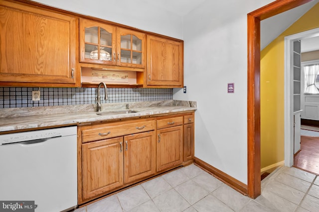 kitchen with tasteful backsplash, light tile patterned flooring, sink, and white dishwasher