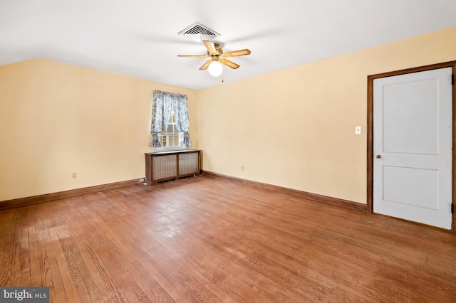 spare room featuring radiator, hardwood / wood-style flooring, and ceiling fan