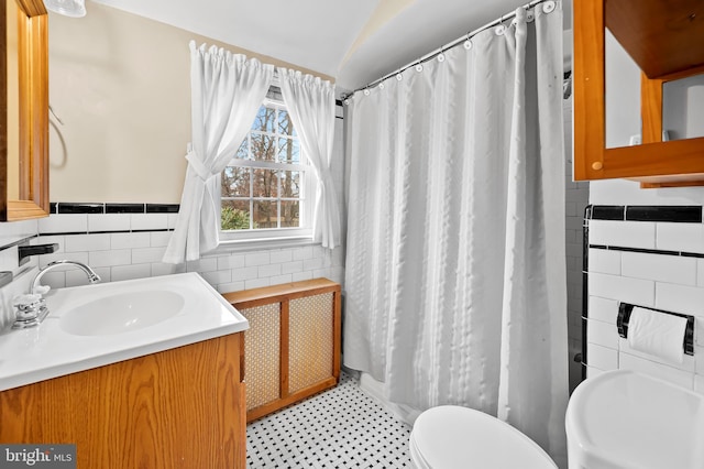 bathroom featuring vanity, tile walls, curtained shower, and toilet