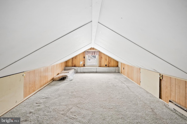 bonus room with light colored carpet, a baseboard radiator, lofted ceiling with beams, and wood walls