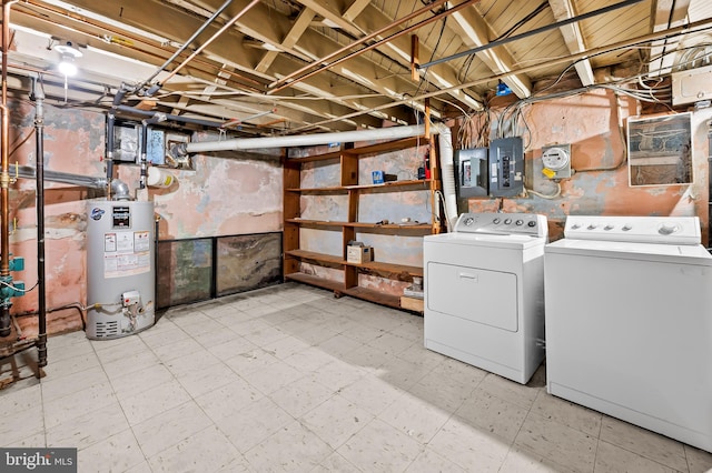 basement featuring gas water heater, electric panel, and washer and clothes dryer