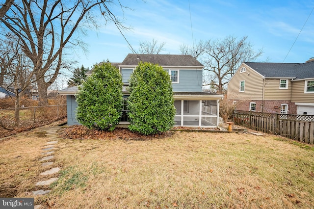 rear view of house with a yard and a sunroom