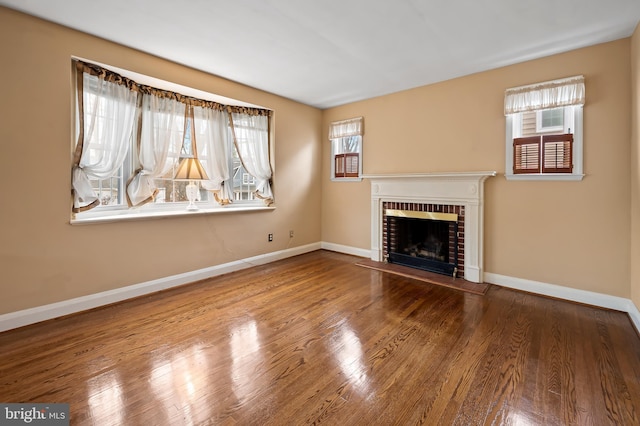 unfurnished living room with a brick fireplace and wood-type flooring