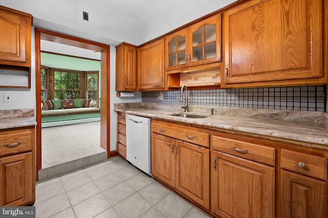 kitchen featuring dishwasher, sink, light tile patterned flooring, and decorative backsplash