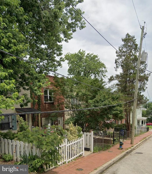 view of front of home featuring brick siding and a fenced front yard