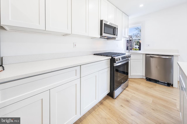 kitchen featuring white cabinetry, appliances with stainless steel finishes, and light countertops