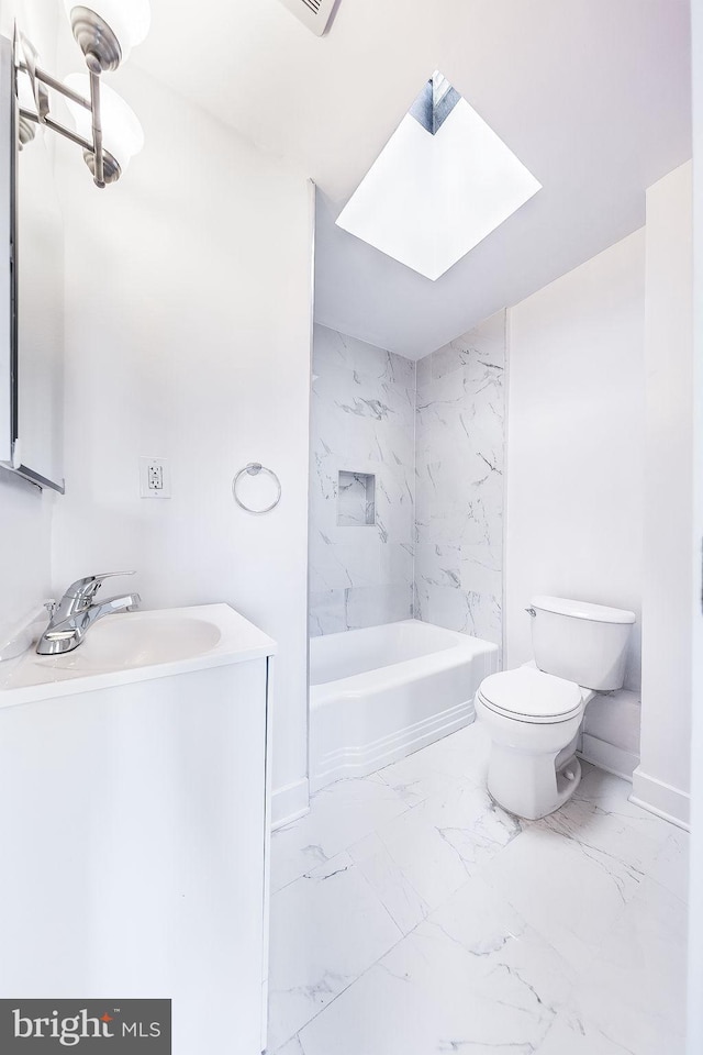 bathroom with a skylight, toilet, marble finish floor, vanity, and shower / washtub combination