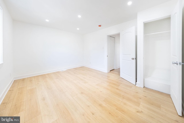 empty room featuring light wood-style floors, baseboards, and recessed lighting