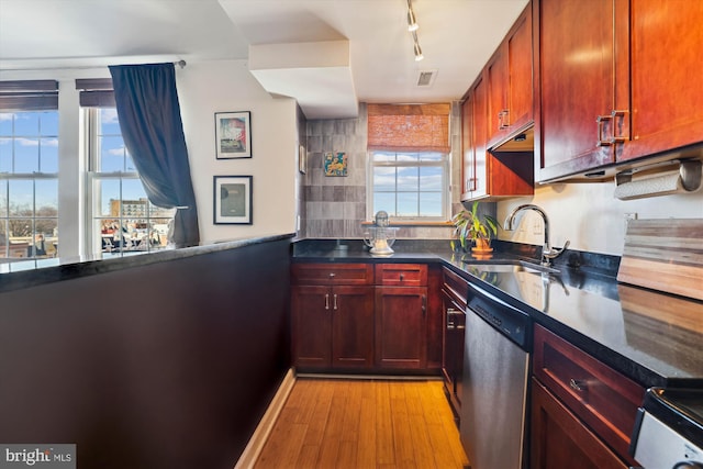 kitchen featuring dishwasher, rail lighting, sink, stove, and light hardwood / wood-style floors