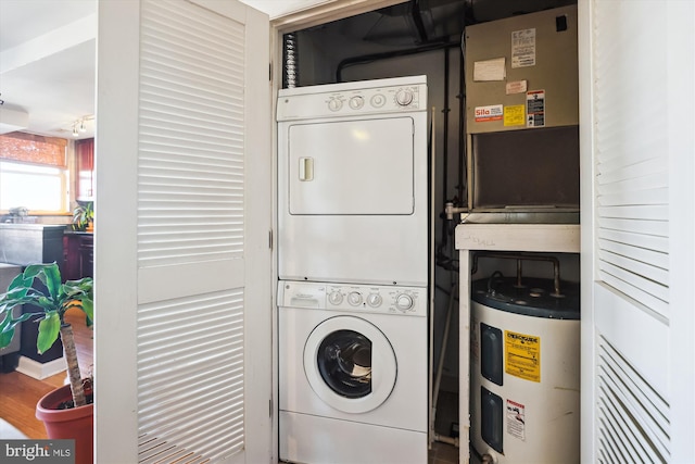 clothes washing area with electric water heater and stacked washer / dryer