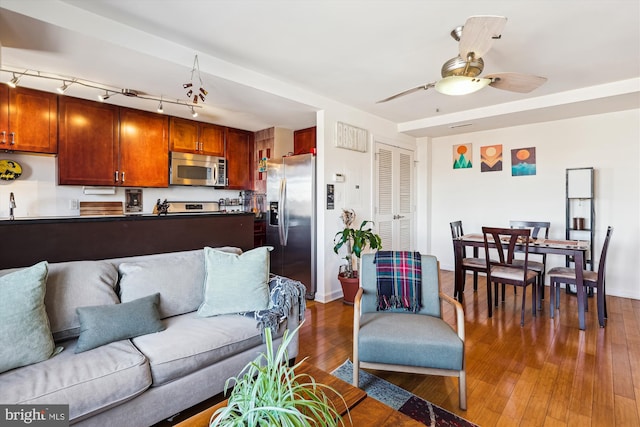 living room with dark wood-type flooring and ceiling fan