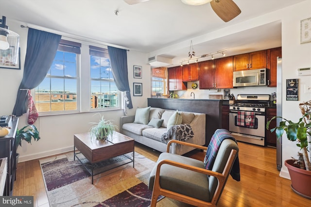 living room featuring ceiling fan, sink, track lighting, and light wood-type flooring