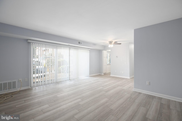 empty room with ceiling fan, plenty of natural light, and light hardwood / wood-style floors