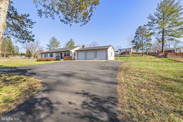 view of front of property with a garage, an outdoor structure, and a front lawn